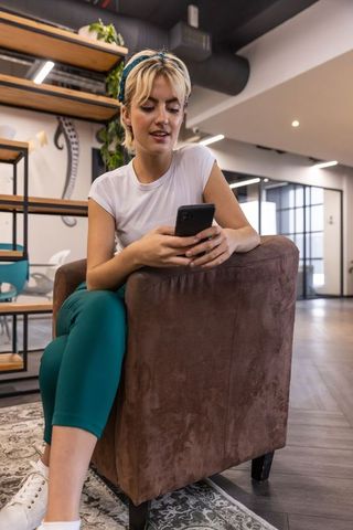 Woman in coworking space using smartphone for work