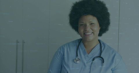 Smiling nurse wearing blue scrubs and stethoscope, clinical headshot for healthcare marketing