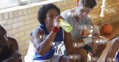 Basketball players hydrating and resting on court bench with social engagement overlays