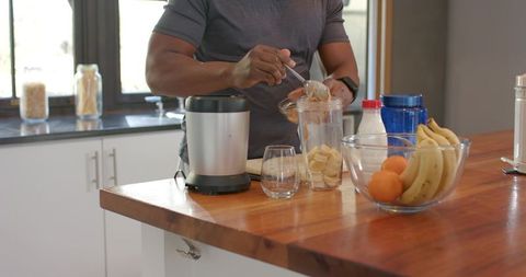 Preparing nutritious banana smoothie in modern kitchen