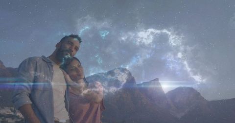Couple leaning at mountain overlook embracing under nebula sky at twilight