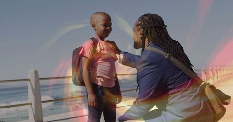 Father Adjusting Son's Backpack on Seaside Walkway Adventure