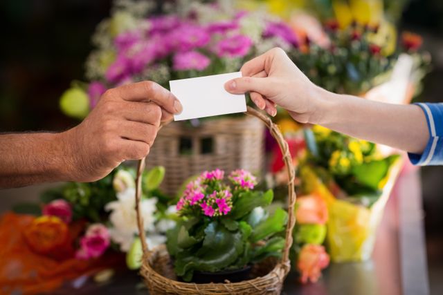 Florist handing business card to customer in flower shop. Ideal for illustrating small business interactions, customer service, and retail environments. Useful for marketing materials, business promotions, and customer engagement visuals.