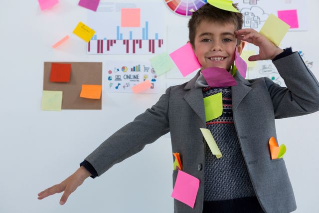 Boy as business executive with sticky notes on his body in office