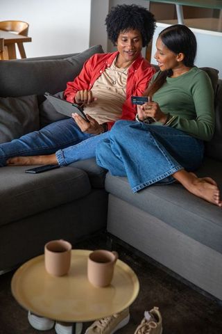 Diverse Couple Using Digital Tablet for Online Shopping at Home