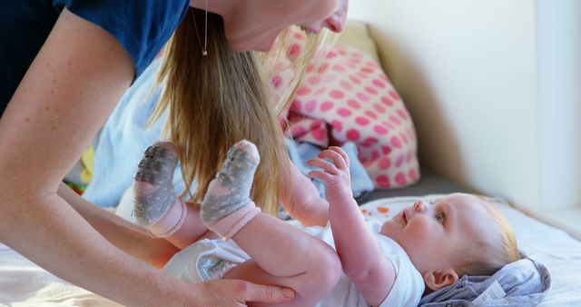 Mother Interacting with Happy Baby on Changing Table in Sunlit Room - Download Free Stock Images Pikwizard.com