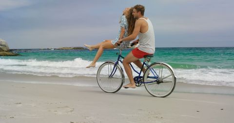 Happy Couple Enjoying Bicycle Ride on Sandy Beach - Download Free Stock Images Pikwizard.com