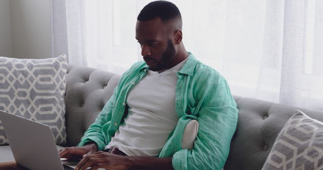 Focused Man Working on Laptop at Home, Sitting on Comfortable Sofa - Download Free Stock Images Pikwizard.com