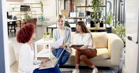 Diverse Female Team Collaborates in Modern Office Lounge