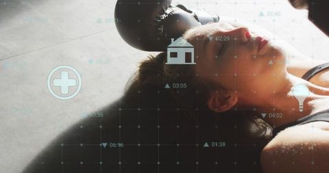 Female boxer lying on gym floor sweating with medical hud overlay for fitness recovery