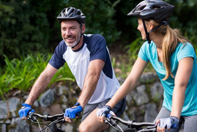 Smiling athletic couple cycling on the open road