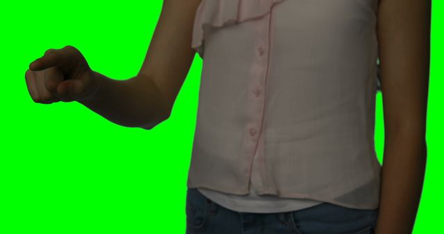 Woman's torso in casual attire with hand making a pointing gesture against a green screen background. Ideal for uses in mockup designs, green screen effects, user interaction models, presentations, and educational materials.