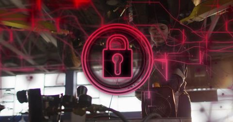 Female technician adjusting industrial machinery with neon cybersecurity lock overlay