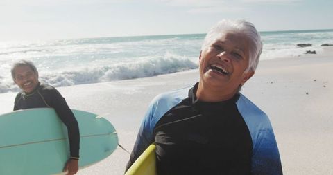 Senior Couple Joyfully Surfing at Sunny Beach