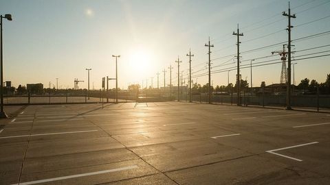 Sunrise Lighting Empty Urban Parking Lot with Golden Rays
