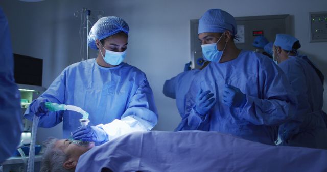 The medical team is carrying out a surgery in a well-equipped operating room. The anesthesiologist in blue scrubs is monitoring the patient's condition while the surgeons work. This image reflects the intensity and precision of medical procedures. Useful for articles, blogs, and educational materials related to healthcare, surgery, medical careers, and hospital settings.
