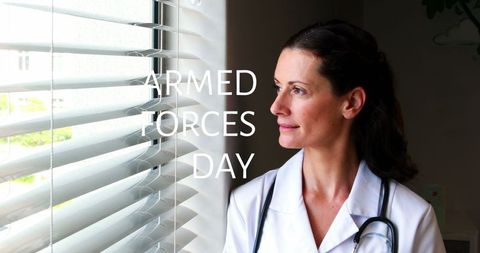 Female doctor celebrating armed forces day near window