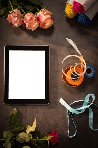 Transparent Tablet with Floral and Ribbon Arrangement on Table