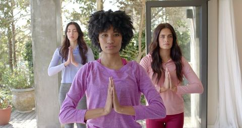Women Practicing Yoga Indoors with Focused Expressions