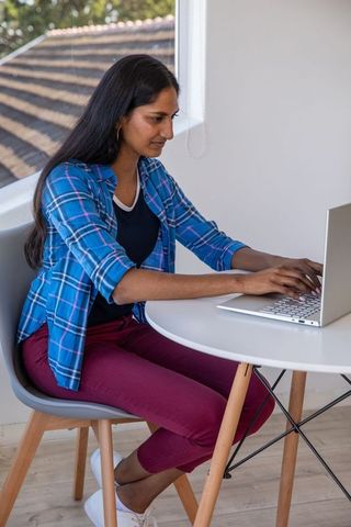Indian Woman Working Remotely on Laptop in Minimalist Workspace