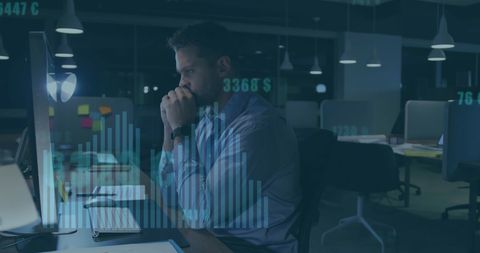 Businessman analyzing digital data in office at night