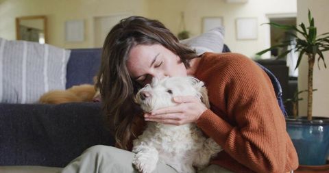 Woman Hugging Fluffy Dog in Cozy Living Room Interior