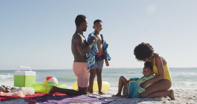 Smiling african american parents toweling off their children on sunny beach - Download Free Stock Photos Pikwizard.com