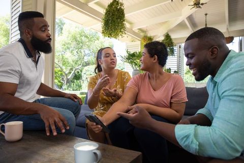 Diverse Friends Enjoy Casual Gathering on Outdoor Porch Lounge