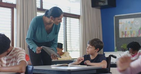 Teacher using tablet to engage students in modern classroom
