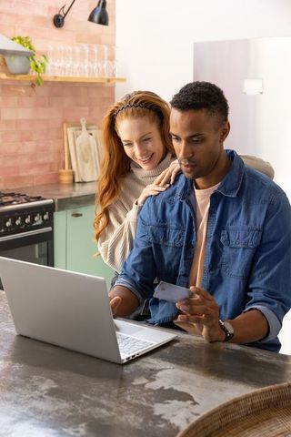 Couple shopping online in modern kitchen interior