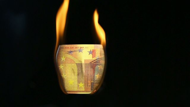 Image of a euro bill engulfed in flames against a dark backdrop symbolizing economic challenges or financial ruin. Can be used for articles on economic collapse, financial instability, or investments going bad.