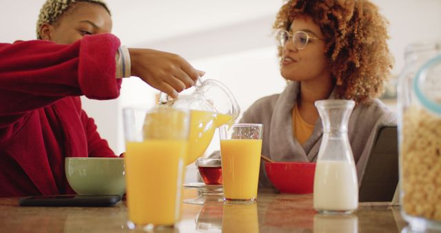 Two Friends Enjoying Breakfast with Orange Juice at Home - Download Free Stock Images Pikwizard.com
