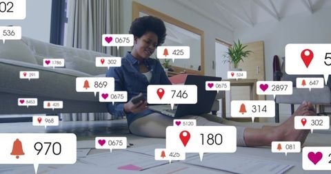 Black woman working from home balancing laptop and smartphone amid notification overload