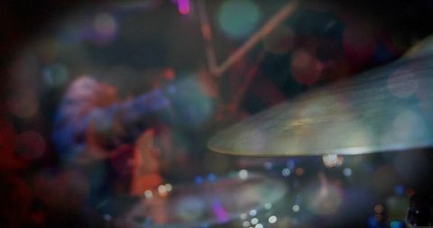 Live music performance with vibrant lighting and drum cymbal