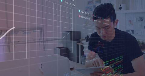Young Asian Man Analyzing Stock Market Data on Tablet