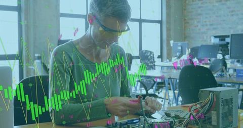 Technician wearing safety glasses and wiring electronics in workshop