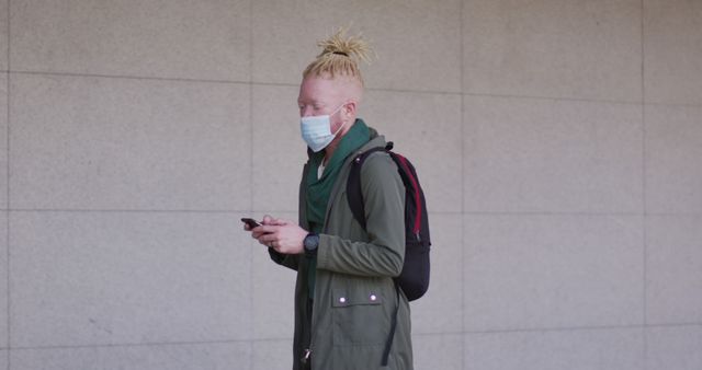 Man with Dreadlocks Texting while Wearing Face Mask Outdoors - Download Free Stock Images Pikwizard.com