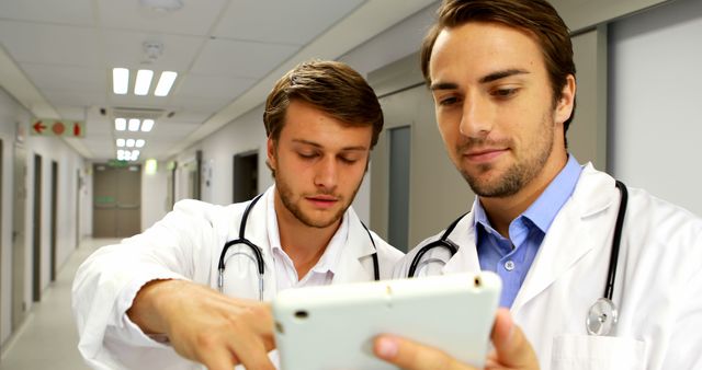 Doctors Discussing Medical Information on Digital Tablet in Hospital Corridor - Download Free Stock Images Pikwizard.com