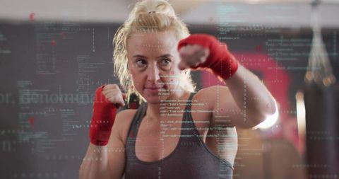 Female boxer wearing red hand wraps throwing focused punch with code overlay