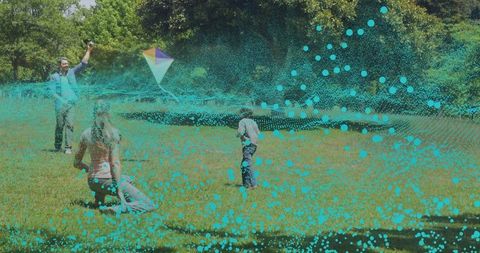 Family flying colorful kite in sunlit park with playful turquoise digital particle overlay