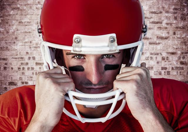 Digital composition of american football player holding helmet against brick wall background