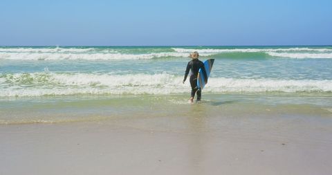 Senior Female Surfer Holding Surfboard Heading Into Ocean - Download Free Stock Images Pikwizard.com