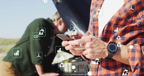 Men repairing car breakdown guided by smartphone in countryside