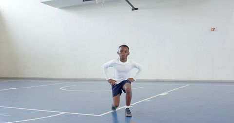 Young Athlete Practicing Lunges on Indoor Basketball Court