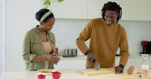 African American Couple Preparing Homemade Pie in Bright Modern Minimalist Kitchen