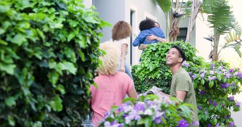 Diverse Couples Arriving at Home Gathering with Wine and Flowers