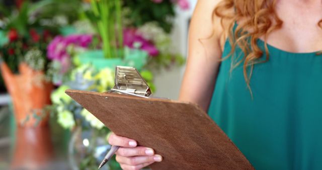 Florist With Curly Hair Holding Clipboard In Flower Shop - Download Free Stock Images Pikwizard.com