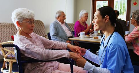 Doctor consoling elderly woman in nursing home