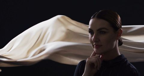 Thoughtful Woman Observing Flowing Fabric - Download Free Stock Images Pikwizard.com