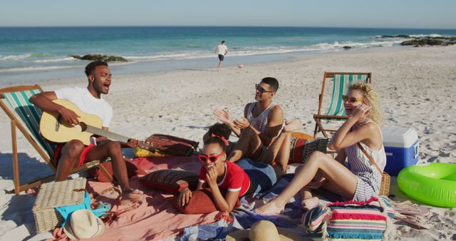 Friends singing and relaxing on sunny beach - Download Free Stock Images Pikwizard.com